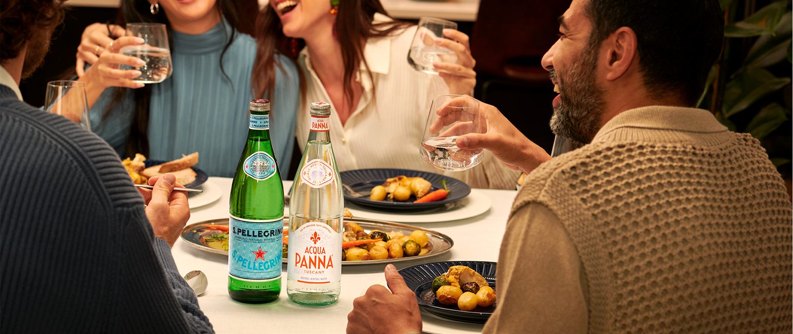 Friends sharing a meal with S.Pellegrino and Acqua Panna